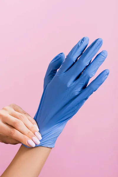 Ausgeschnittene Ansicht einer Frau, die Latex-Handschuhe anzieht, isoliert auf rosa — Stockfoto