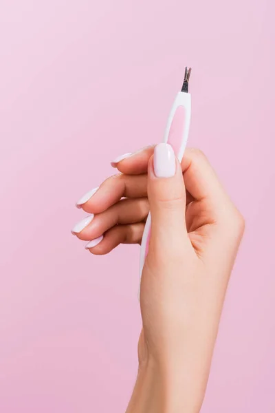 Vista ritagliata della donna che tiene cuticola clipper isolato su rosa — Foto stock