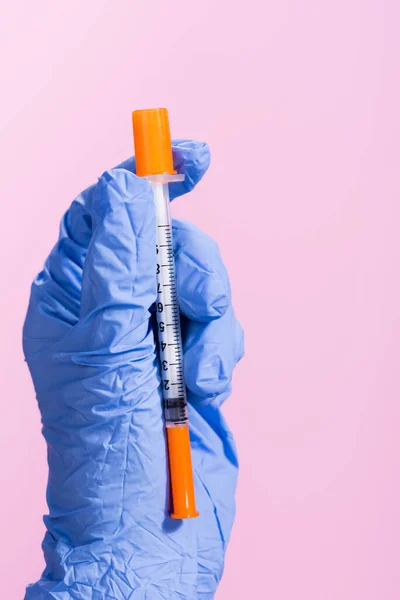 Обрезанный вид руки в латексной перчатке с вакциной, изолированной на розовый — стоковое фото