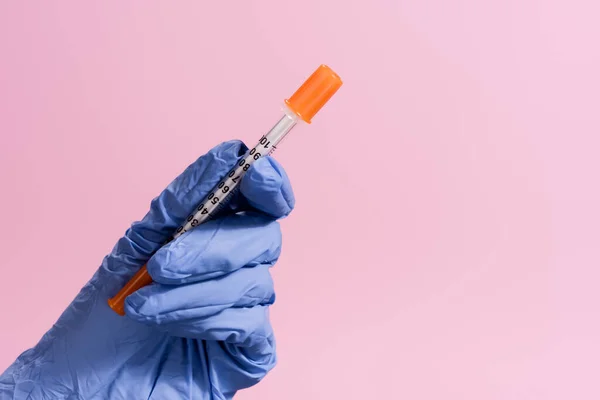 Vue recadrée de la main en gant de latex avec vaccin isolé sur rose — Photo de stock