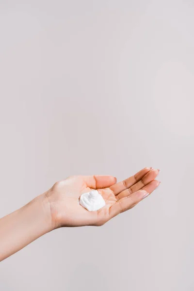 Vue recadrée de la femme montrant crème pour les mains isolée sur gris — Photo de stock