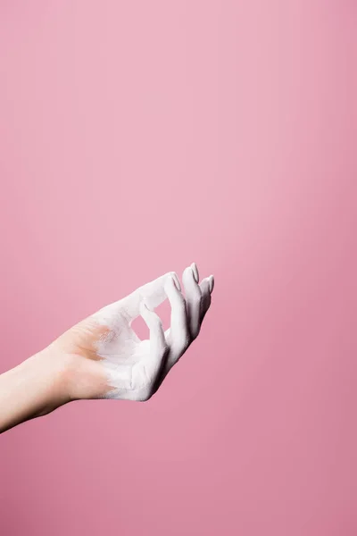 Vista recortada de la mano pintada de blanco aislado en rosa - foto de stock