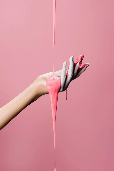 Cropped view of hand with dripping paint isolated on pink — Stock Photo