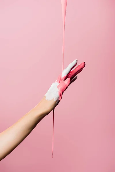 Cropped view of hand with dripping paint isolated on pink — Stock Photo