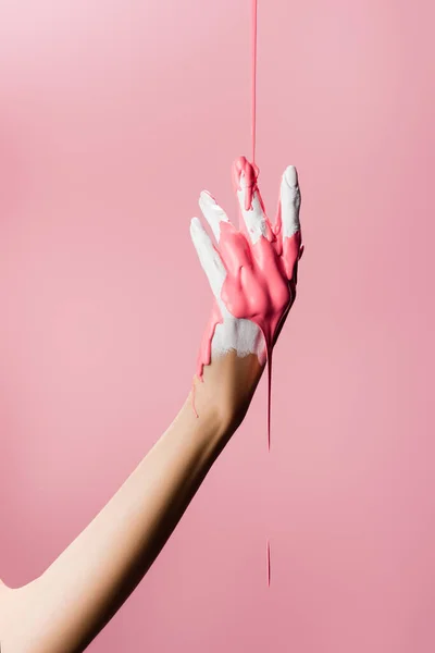 Vista cortada da mão com tinta gotejamento isolado em rosa — Fotografia de Stock