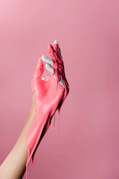 Обрезанный вид руки с капающей краской изолированы на розовый — стоковое фото
