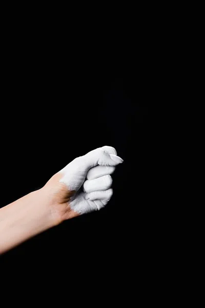 Partial view of white painted fist isolated on black — Stock Photo