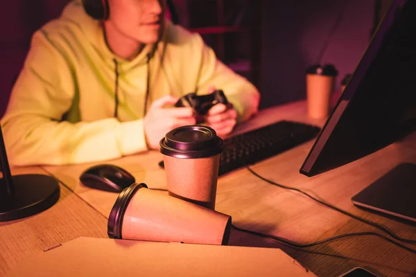 Café à emporter et boîte à pizza près du gamer avec joystick et ordinateur sur fond flou — Photo de stock