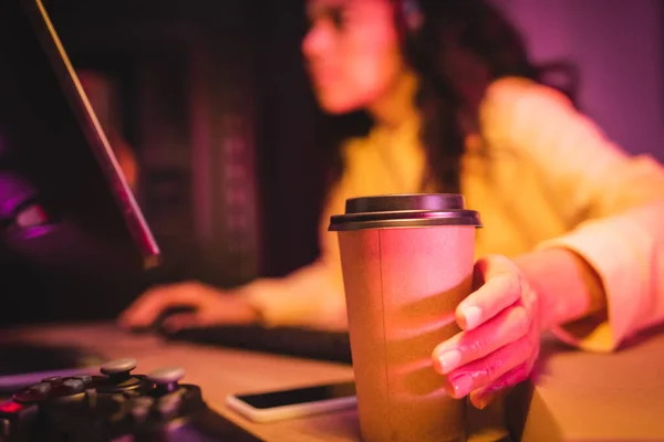 KYIV, UCRAINA - AGOSTO 21, 2020: Caffè per avvicinarsi joystick e gamer utilizzando il computer su sfondo sfocato — Foto stock