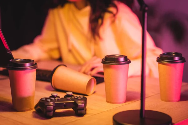 KIEW, UKRAINE - 21. AUGUST 2020: Kaffee zum Mitnehmen und Steuerknüppel in der Nähe von Gamer und Computer auf verschwommenem Hintergrund — Stockfoto