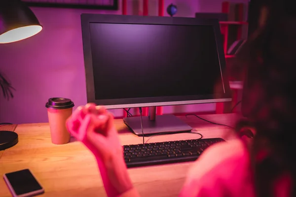 Ordenador con pantalla en blanco cerca de gamer mostrando sí gesto en primer plano borroso - foto de stock