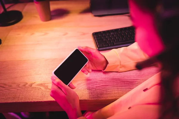 Smartphone with blank screen in hands of gamer on blurred foreground — Stock Photo