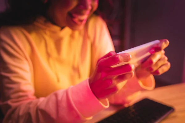 Smartphone dans les mains du joueur afro-américain sur fond flou — Photo de stock