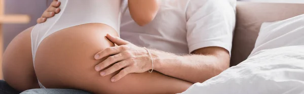 Cropped view of passionate woman in sexy bodysuit sitting on boyfriend, banner — Stock Photo