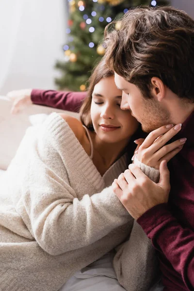 Couple with closed eyes, in warm sweaters hugging at home — Stock Photo