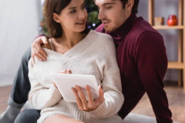 Digitales Tablet in den Händen einer Frau in der Nähe ihres Freundes auf verschwommenem Hintergrund — Stockfoto