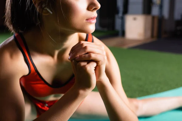 Partial view of sportswoman warming up arms while training in sports center, blurred background — Stock Photo