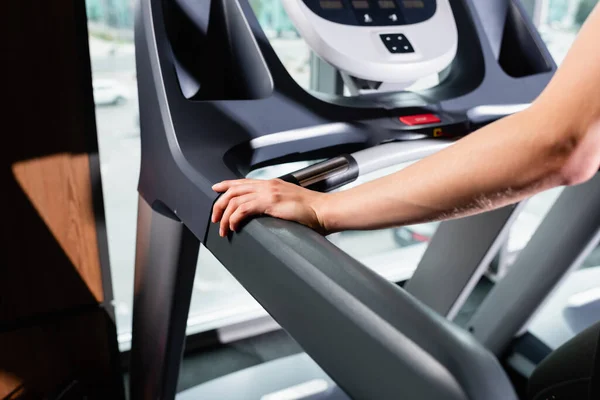 Cropped view of sportswoman on treadmill in sports center — Stock Photo