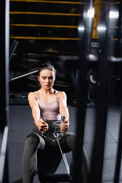 High angle view of athletic sportswoman training on rowing machine on blurred foreground — Stock Photo