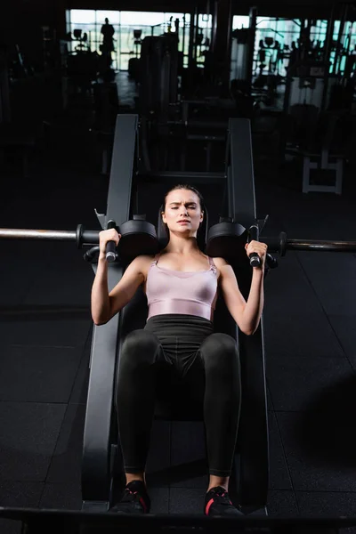 Vista de ángulo alto de la deportista atlética haciendo ejercicio de extensión de brazos en la máquina de entrenamiento - foto de stock