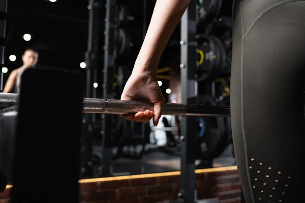 Partial view of sportswoman working out with power rack in gym — Stock Photo