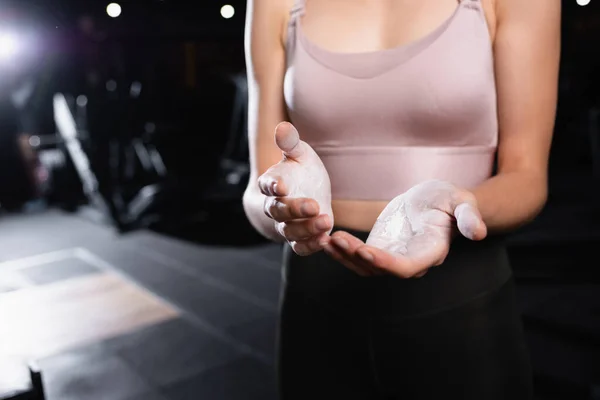 Partial view of sportswoman applying talcum powder on hands in sports center — Stock Photo