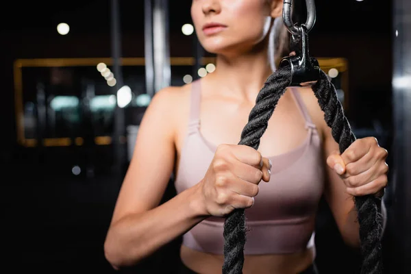 Cropped view of sportswoman training triceps on cable pushdown machine on blurred background — Stock Photo