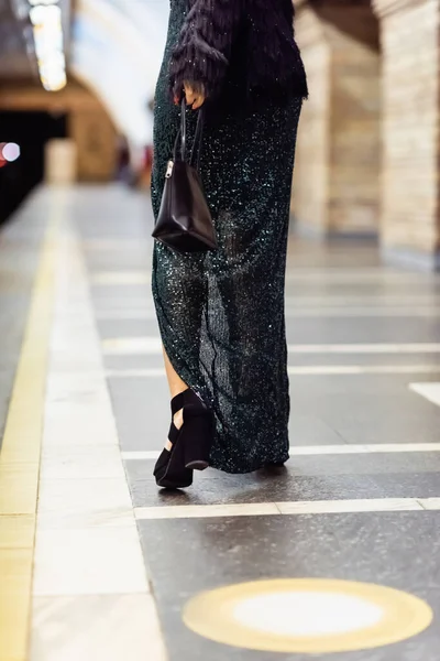 Vue recadrée de la femme élégante en robe noire longue marchant le long de la plate-forme de métro — Photo de stock