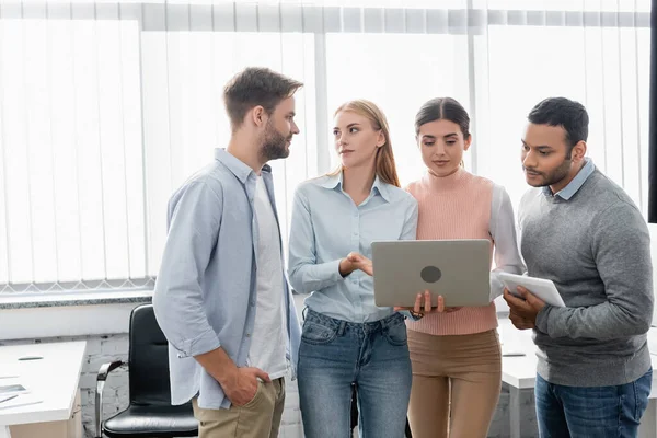 Multicultural businesspeople using laptop and digital tablet in office — Stock Photo