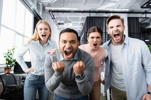 Empresários multiculturais agressivos gritando com a câmera no escritório — Fotografia de Stock