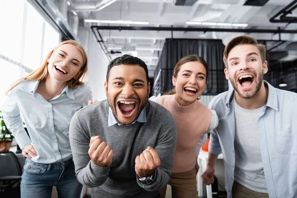 Fröhliche multiethnische Geschäftsleute blicken im Büro in die Kamera — Stockfoto