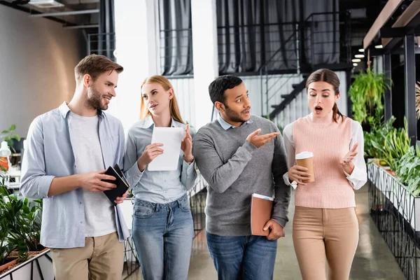 Multicultural businesspeople with digital tablet and coffee to go talking in office — Stock Photo