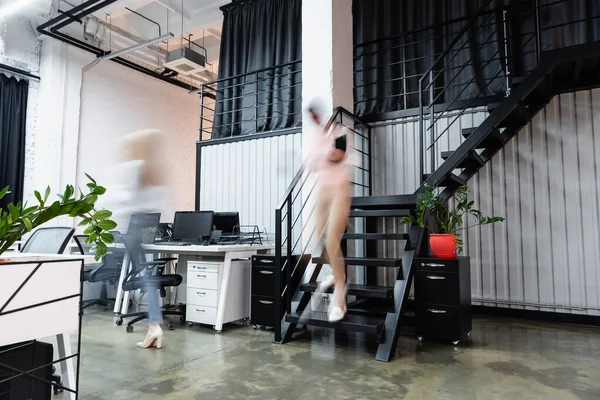 Размытие движения бизнесвумен, идущих в современном офисе — стоковое фото