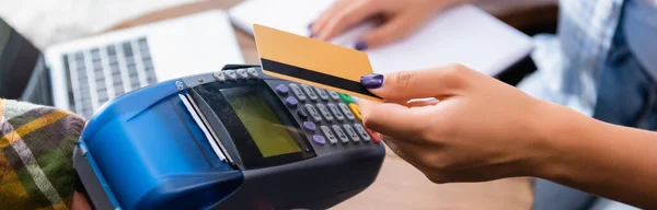 Vista cortada de freelancer pagando com cartão de crédito através de terminal no café, banner — Fotografia de Stock