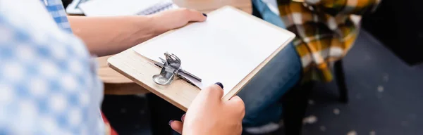 Partial view of waiter holding clipboard with invoice near client, banner — Stock Photo