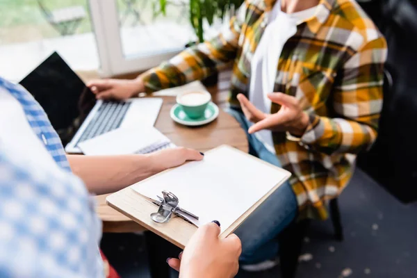 Partial view of freelancer pointing with finger at bill in hands of waiter — Stock Photo