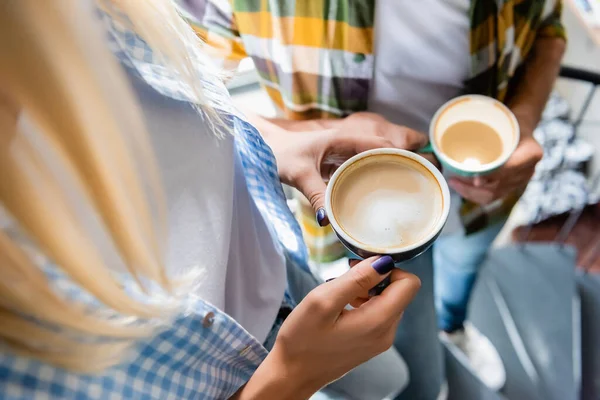 Vue recadrée de l'homme et de la femme tenant des tasses avec cappuccino — Photo de stock