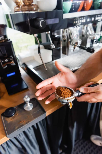 Vue partielle de barista tenant portafilter lors de la préparation du café dans le bar — Photo de stock