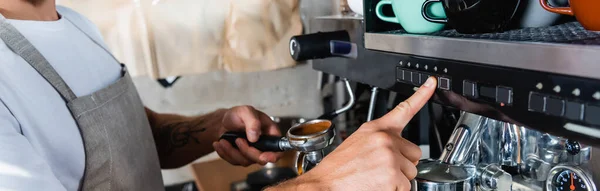 Cropped view of barista operating coffee machine while holding portafilter, banner — Stock Photo