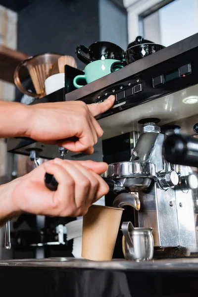 Cropped view of barista pushing button on coffeemaker while preparing coffee to go — Stock Photo
