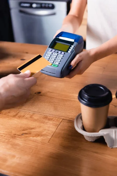 Abgeschnittene Ansicht eines Mannes, der für Kaffee bezahlt, um in den Händen von Barista durch das Terminal zu gehen — Stockfoto