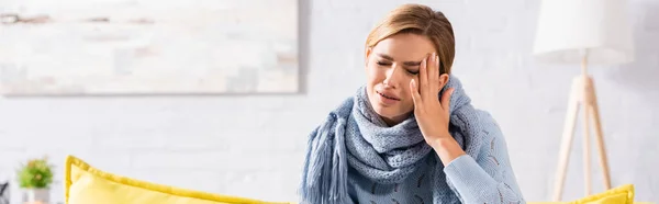 Болезненная женщина в шарфе страдает от головной боли дома, баннер — стоковое фото