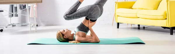 Vista lateral da esportista praticando pose de ioga no tapete de fitness em casa, banner — Fotografia de Stock