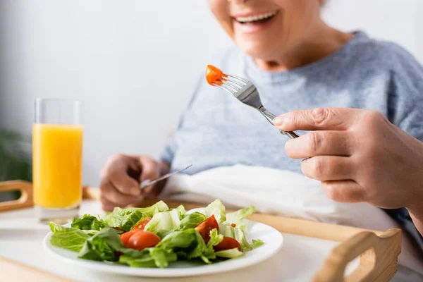 Cropped view of joyful woman having breakfast in hospital, blurred background — Stock Photo