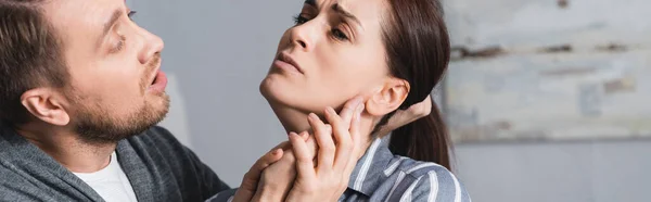 Abusador sosteniendo pelo de esposa asustada en casa, pancarta — Stock Photo