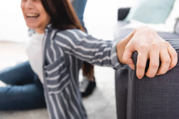 Screaming woman touching couch near abusive husband on blurred background — Stock Photo