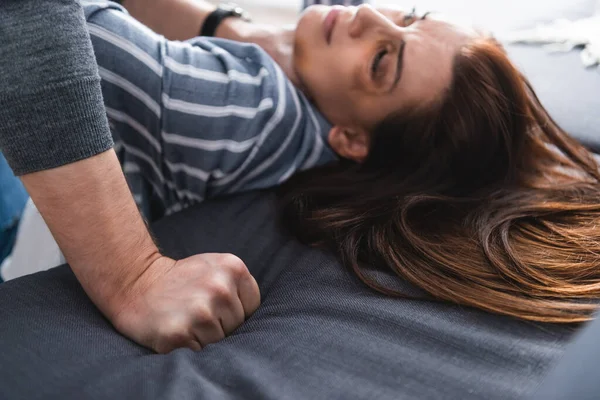 Täter hält Hand in Faust nahe Ehefrau mit Blutergüssen auf verschwommenem Hintergrund — Stockfoto