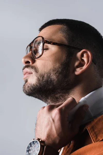 Retrato de hombre barbudo en gafas ajustables cuello alto blanco aislado en gris - foto de stock