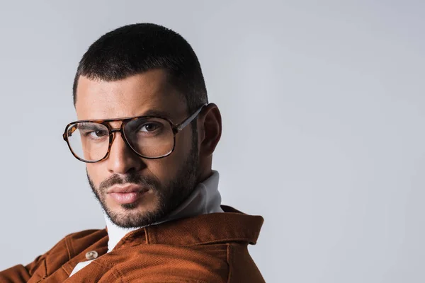 Porträt eines jungen Mannes mit Brille, der isoliert auf graue Kamera blickt — Stockfoto