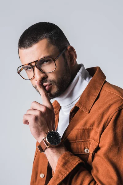 Homme élégant avec des lunettes montrant shh geste à la caméra isolé sur gris — Photo de stock